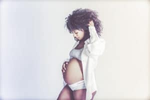 אשה בהריון בסטודיו רקע לבן