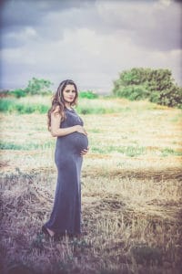 אשה בהריון מצולמת בשדות הכפר