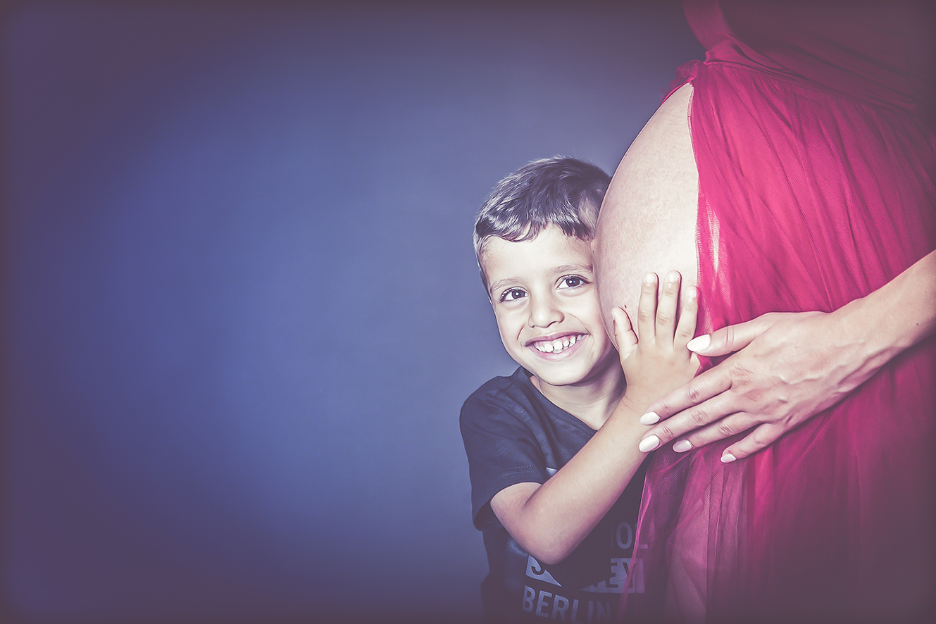 ילד מחבק בטן הריונית בסטודיו